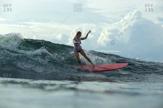 Female Surfer Keeps Her Balance While Surfing On Wave Stock