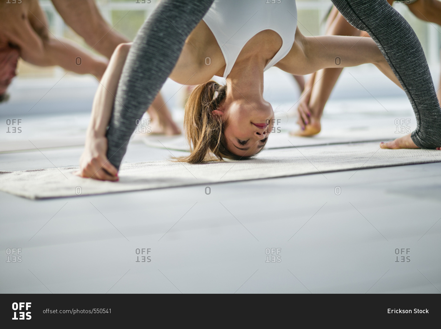 Young Woman Bending Over During A Yoga Class Stock Phot