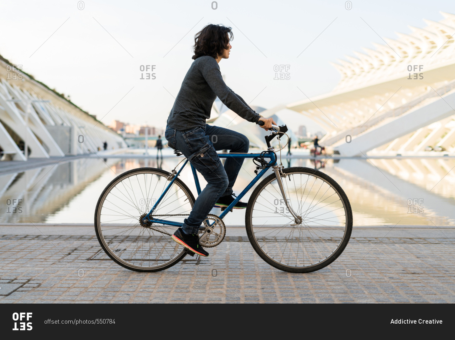 Side view of woman riding a bike in the street. Horizontal outdoors ...