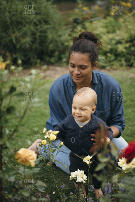 Mother and child looking at flowers in garden