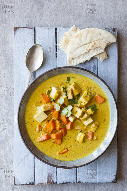 Yellow curry with sweet potato and tofu and naan bread