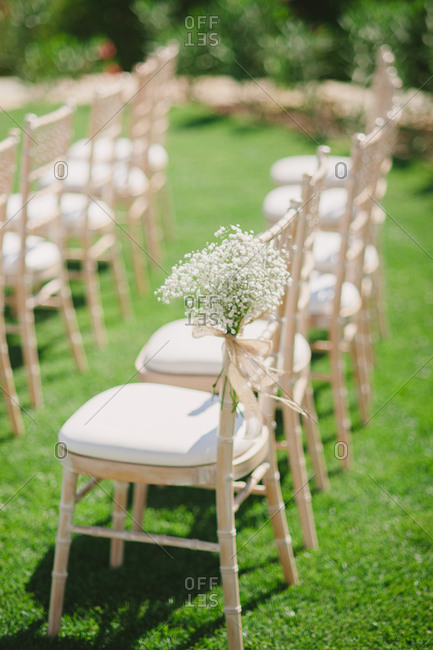 Baby's breath tied to chair at outdoor wedding