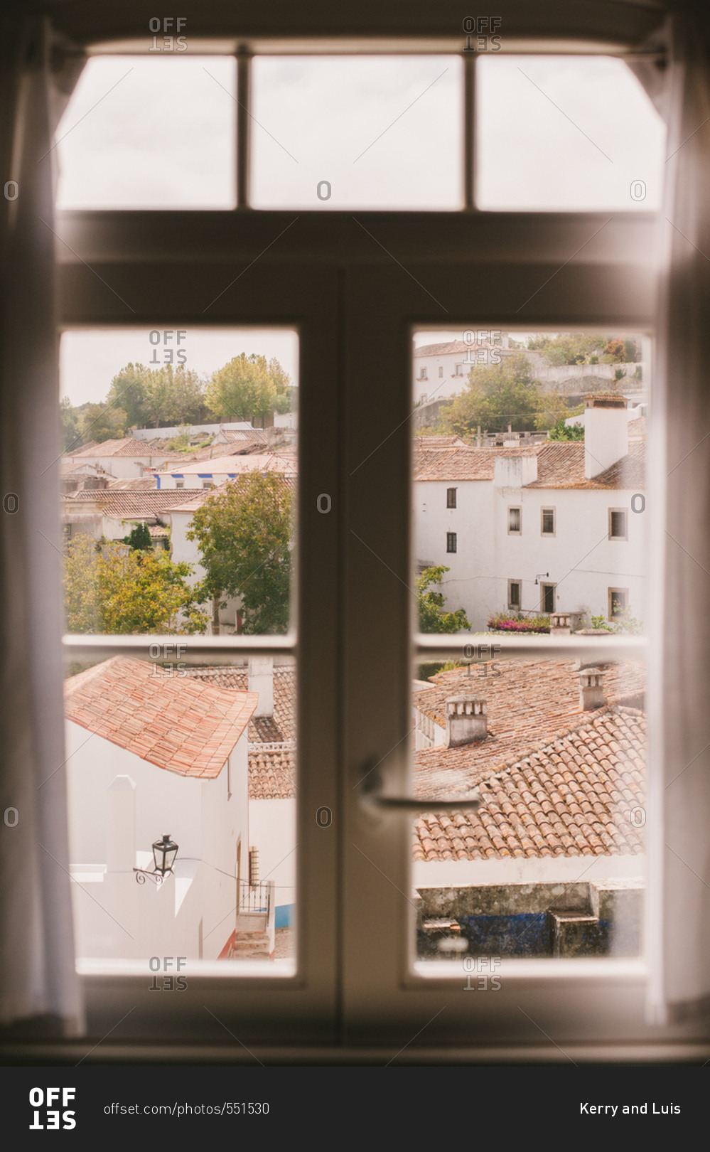 Tile rooftops seen through an upstairs window in Obidos, Portugal