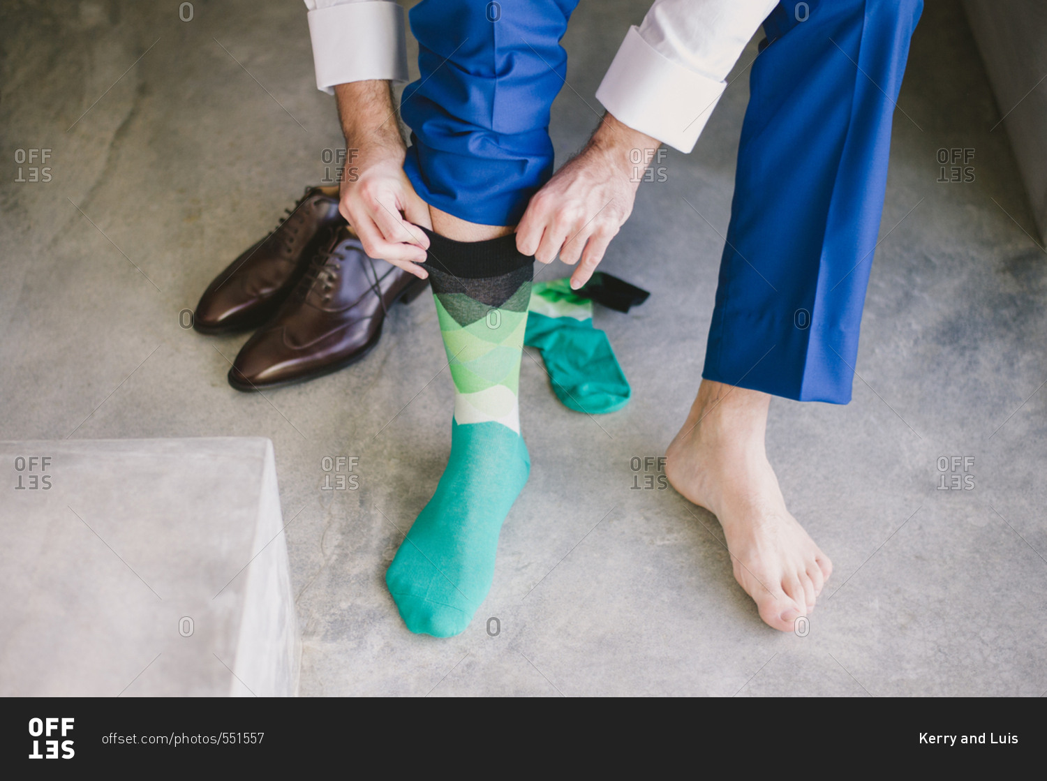Groom in blue suit pants putting on brightly colored socks