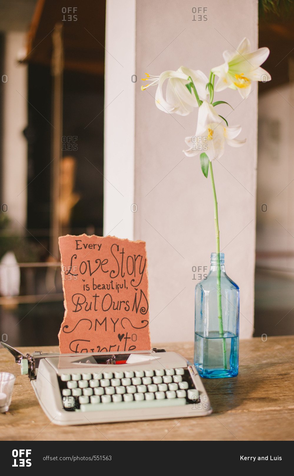 Retro typewriter with handwritten sign and flower in a glass bottle