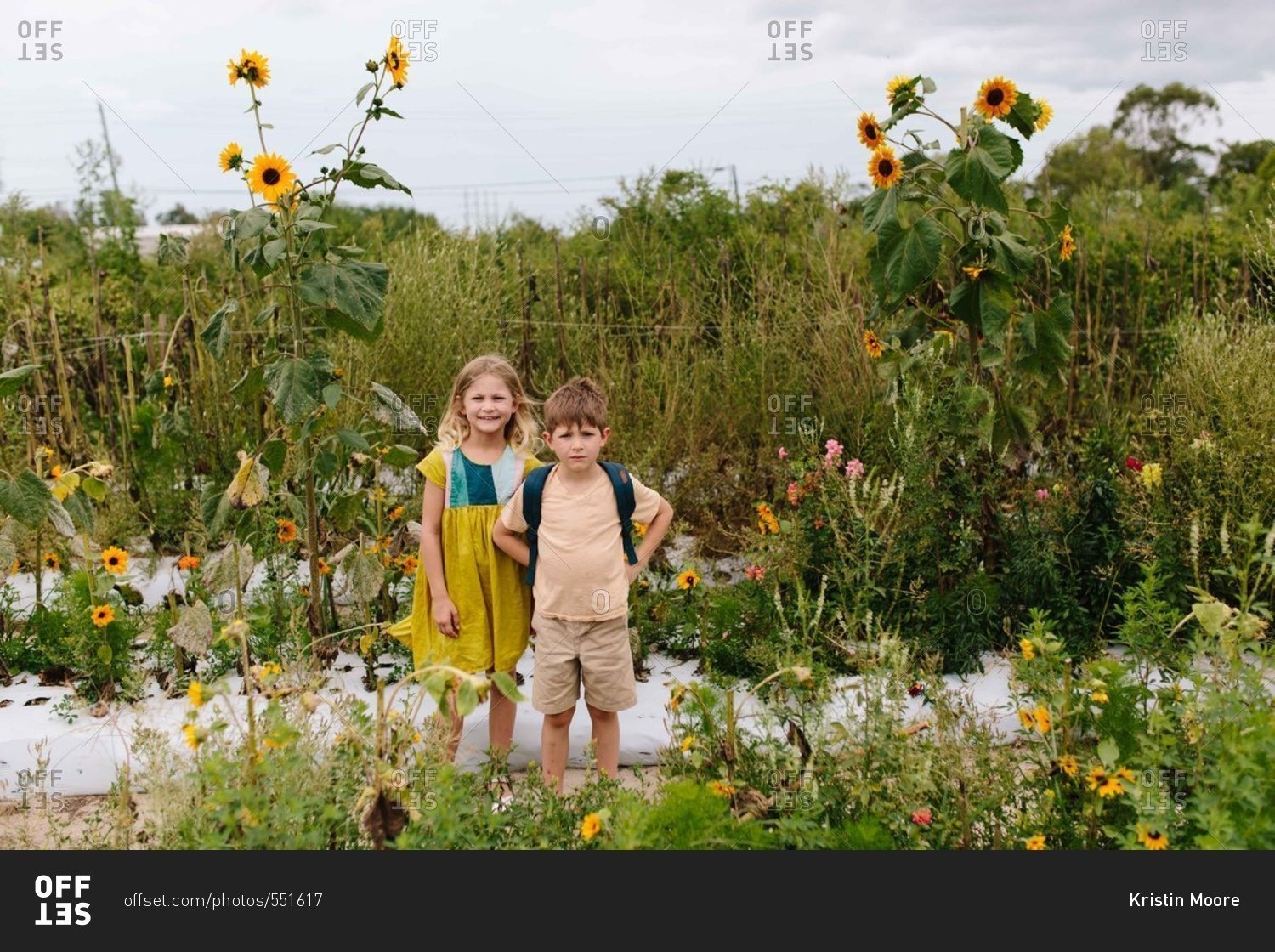 Two kids standing together in a flower garden