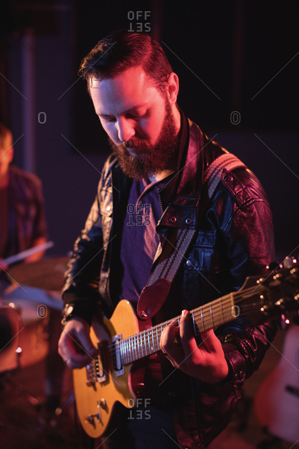 Musician playing electronic guitar in recording studio