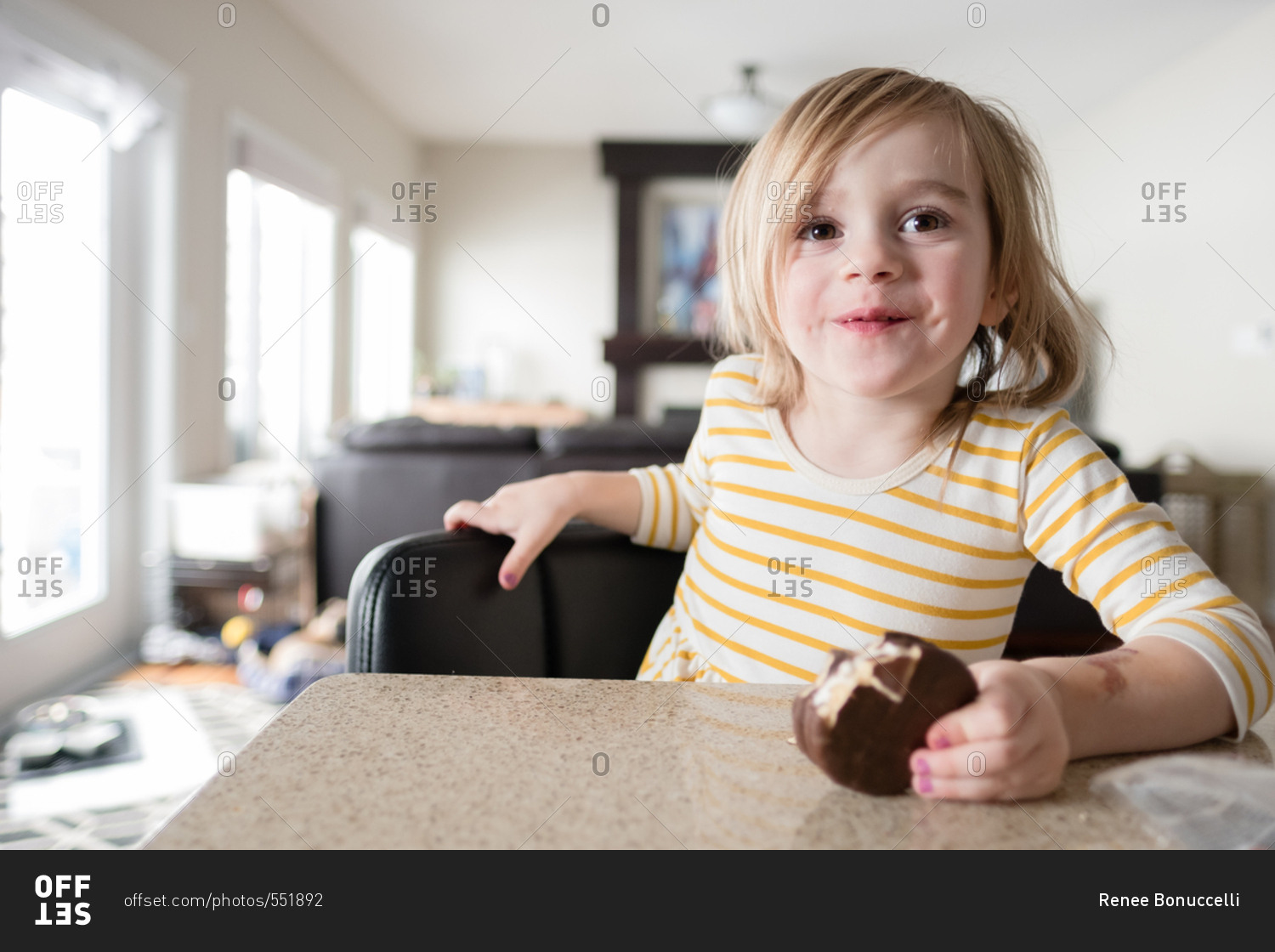Portrait of a girl holding a cookie with a bite missing