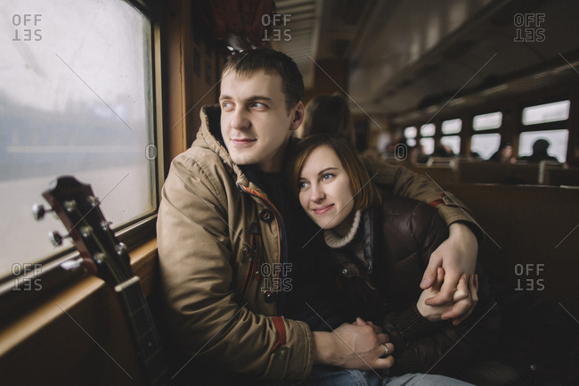 Caucasian couple hugging on train