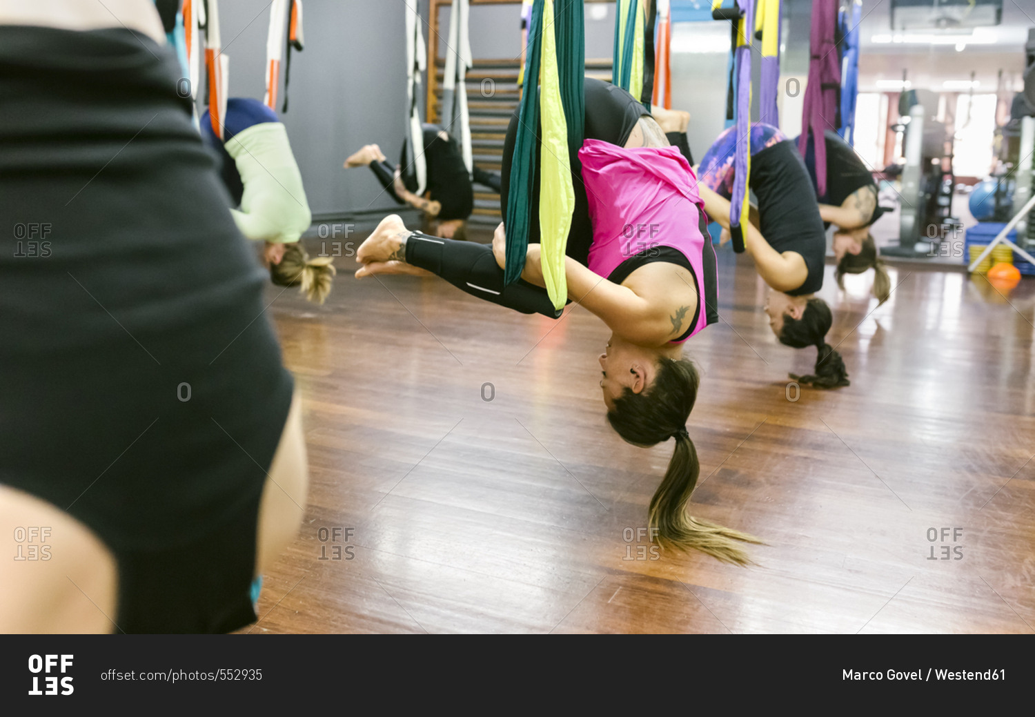 Group of women having a class of aerial yoga