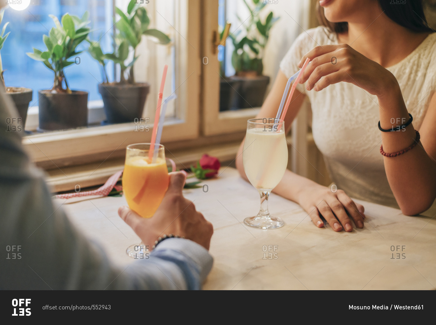 Young couple with drinks in a restaurant- partial view