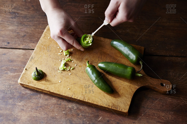 Person removing seeds from jalapeno peppers