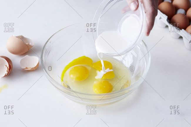 Pouring milk into dish of eggs