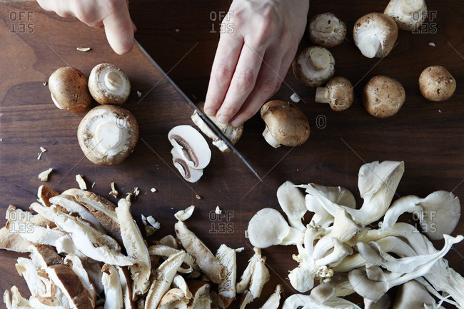 Hands slicing fresh mushrooms - Offset