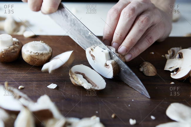 Hands slicing button mushrooms - Offset