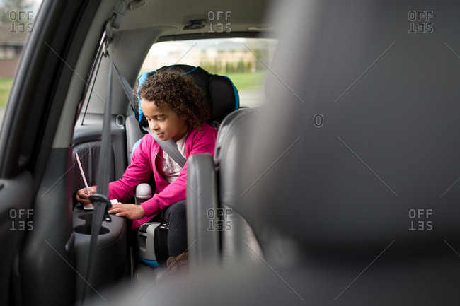 Girl in booster seat in minivan