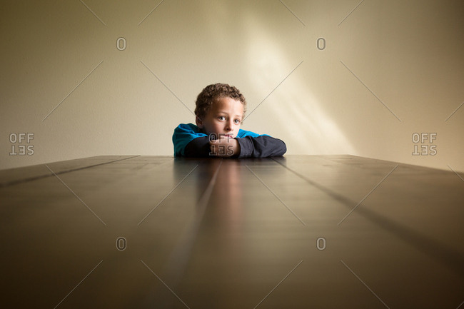 Boy at table staring quietly