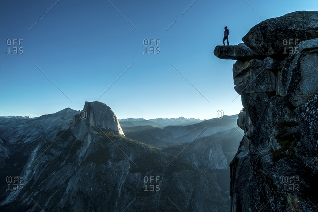 Low angle view of man standing on mountain at Yosemite National Park against clear blue sky