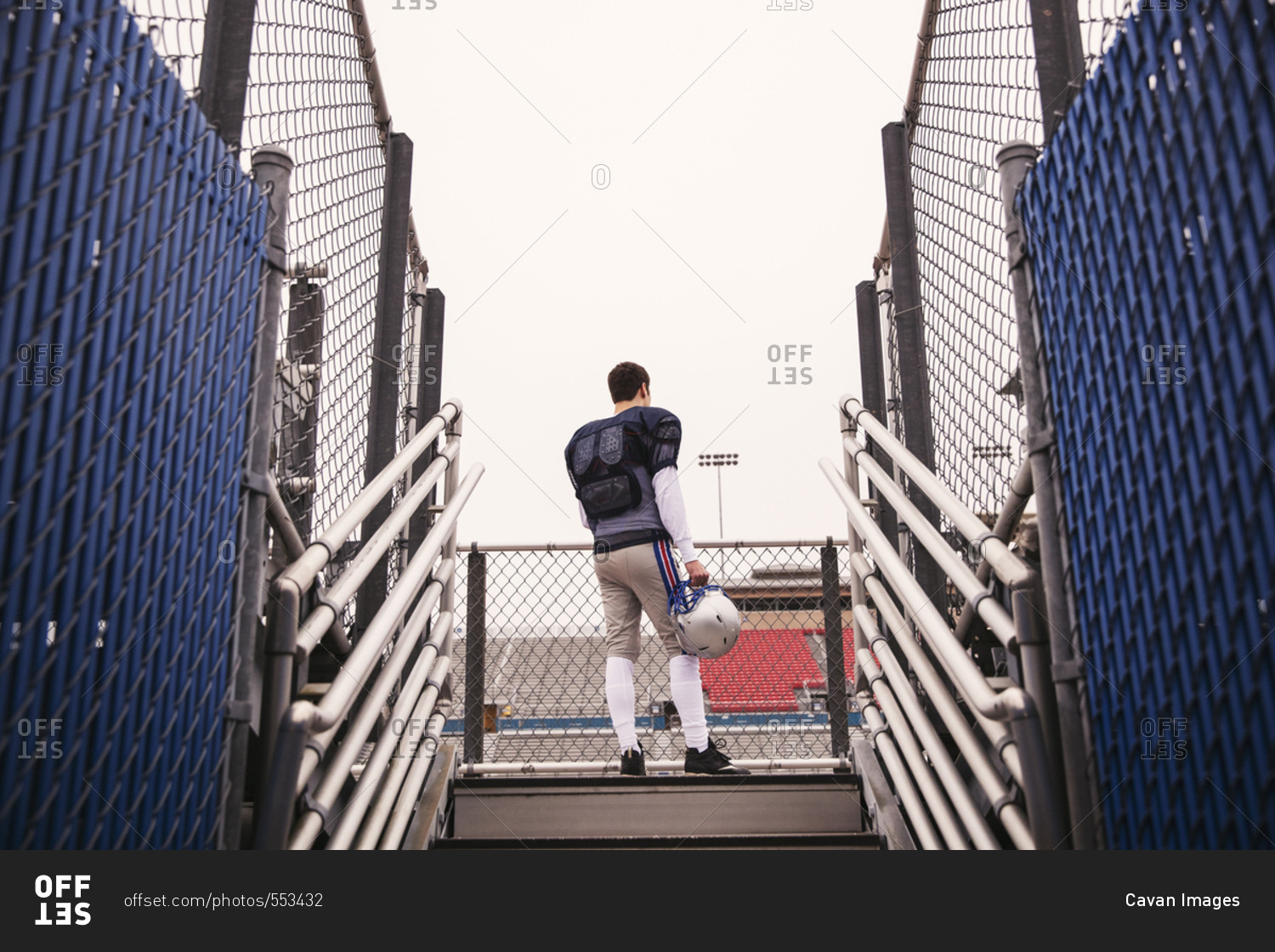 Low angle view of American football player standing against sky at stadium