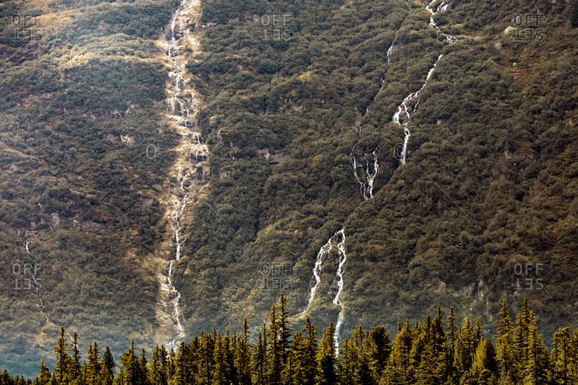 Distant view of waterfalls on green mountain