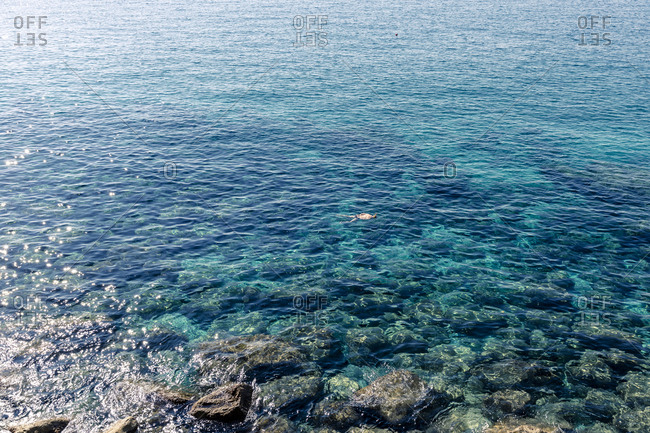 Distant view of person snorkeling in sea