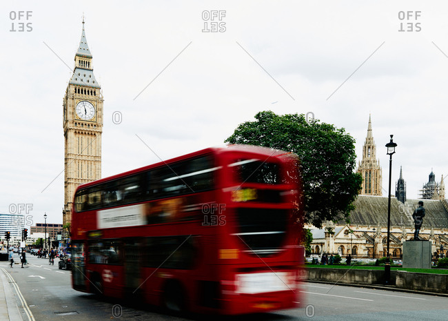 Famous red double-decker bus going down the road towards Big Ben, blurred motion