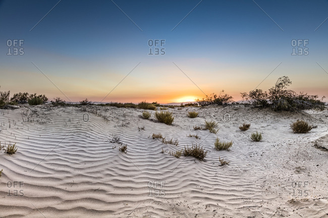 A setting sun over the sand dunes of the Mojave Desert.