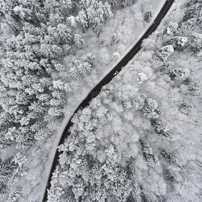 Aerial view of a highway winding through a frozen forest