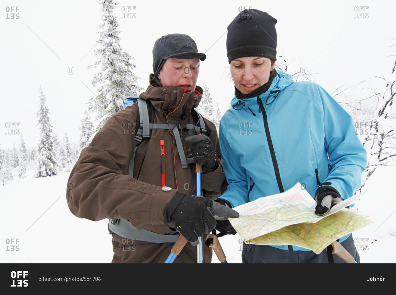 Women looking at map in winter forest