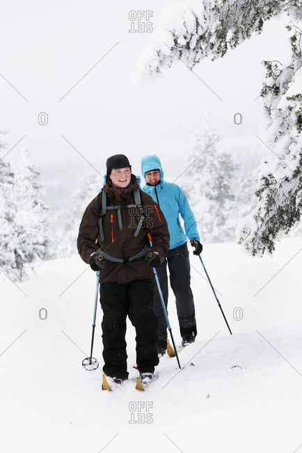 Couple cross country skiing in winter forest