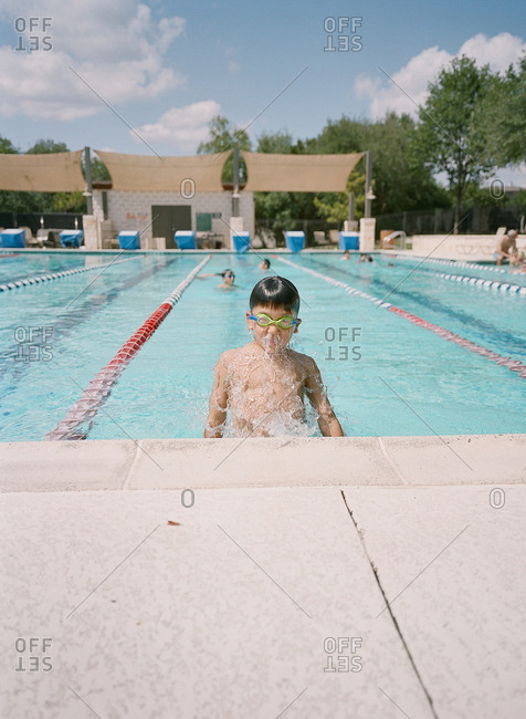Boy popping out of water at end of swim lane