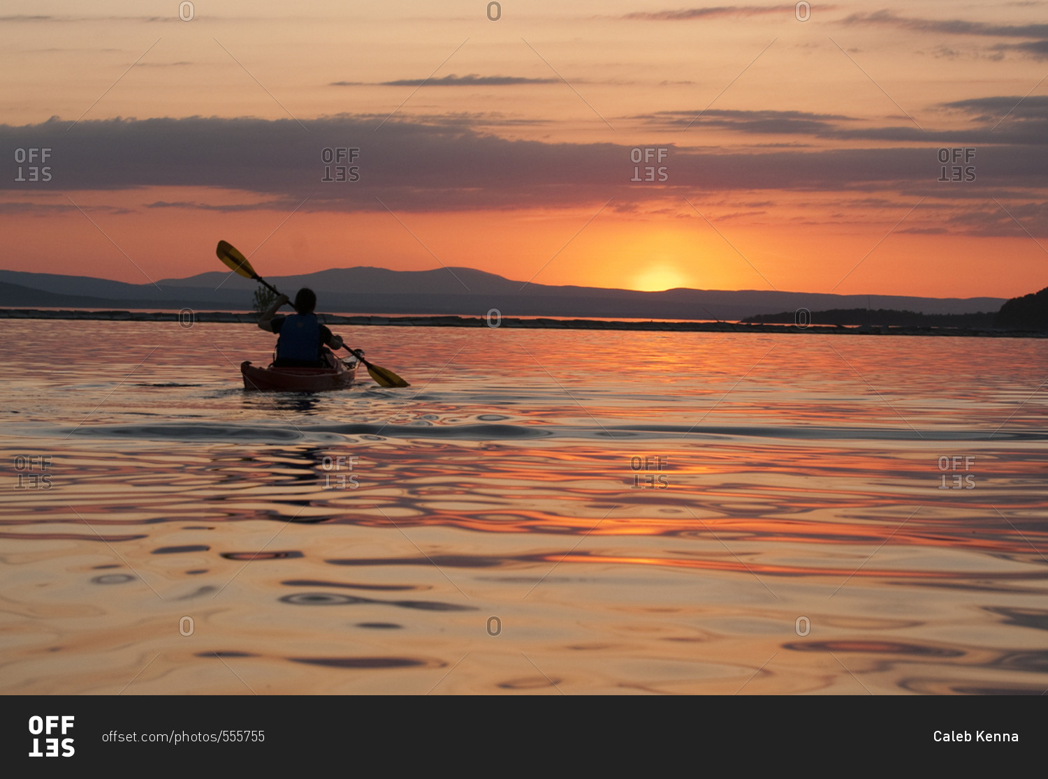 Woman kayaking on Lake Champlain at sunset in Burlington, Vermont