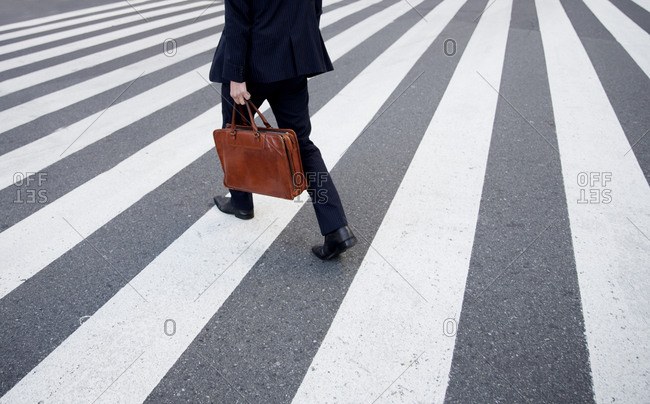 Businessman crossing the street in the Shinjuku area of Tokyo, Japan