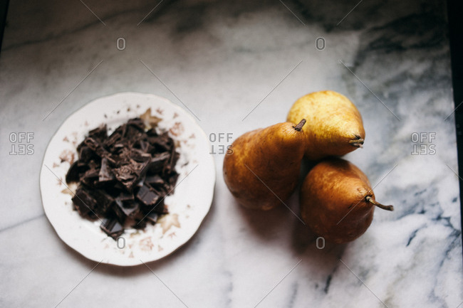 Shaved chocolate and pears on a marble surface