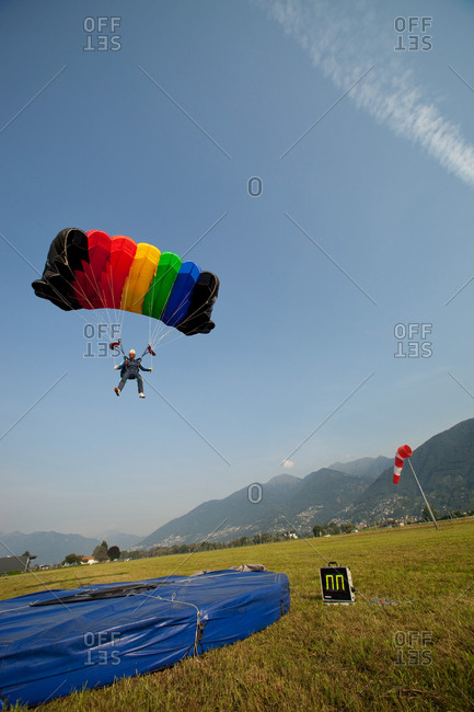 Skydiver with parachute over Locarno, Tessin, Switzerland