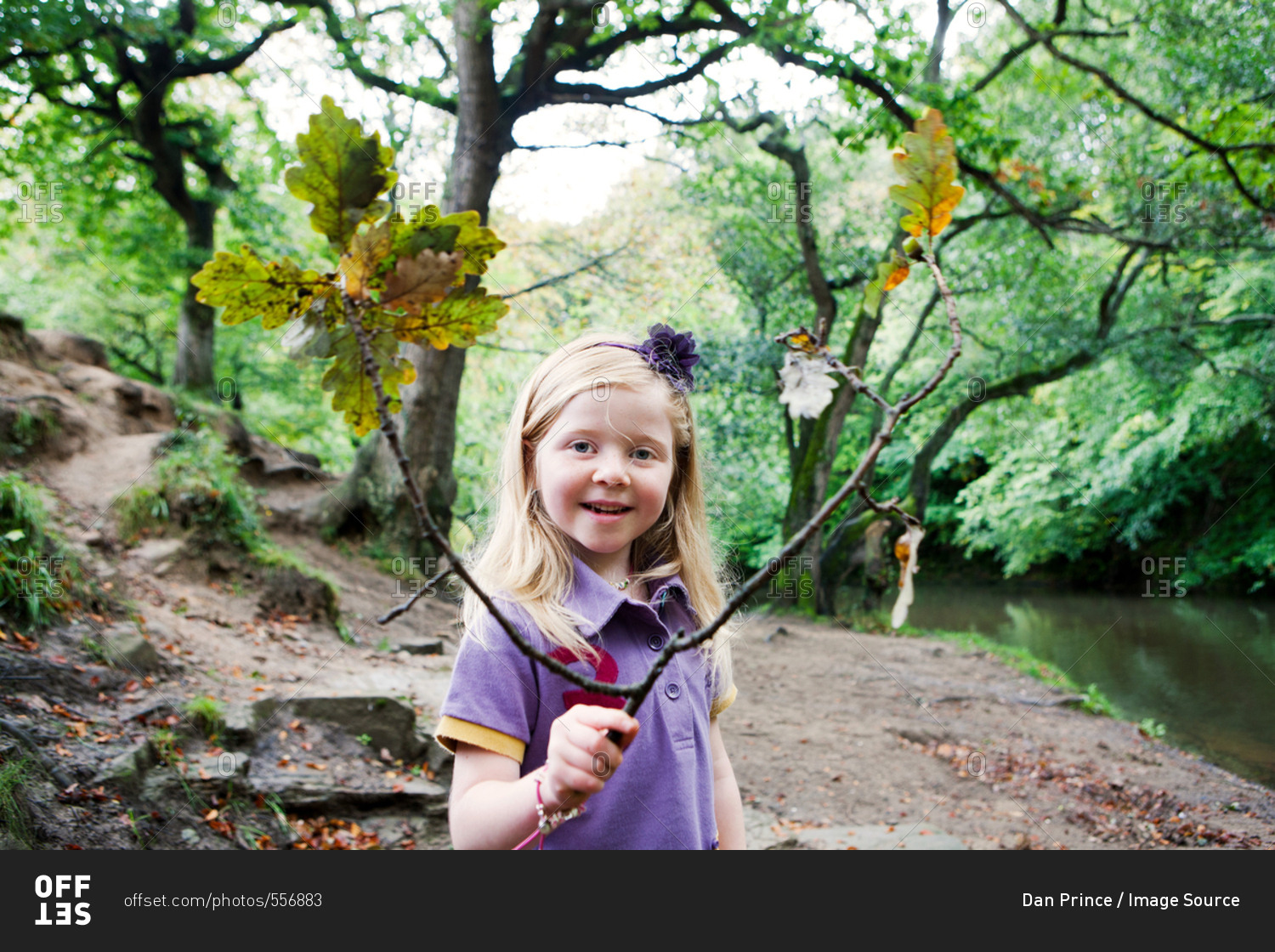 Girl holding an oak branch in a woodland