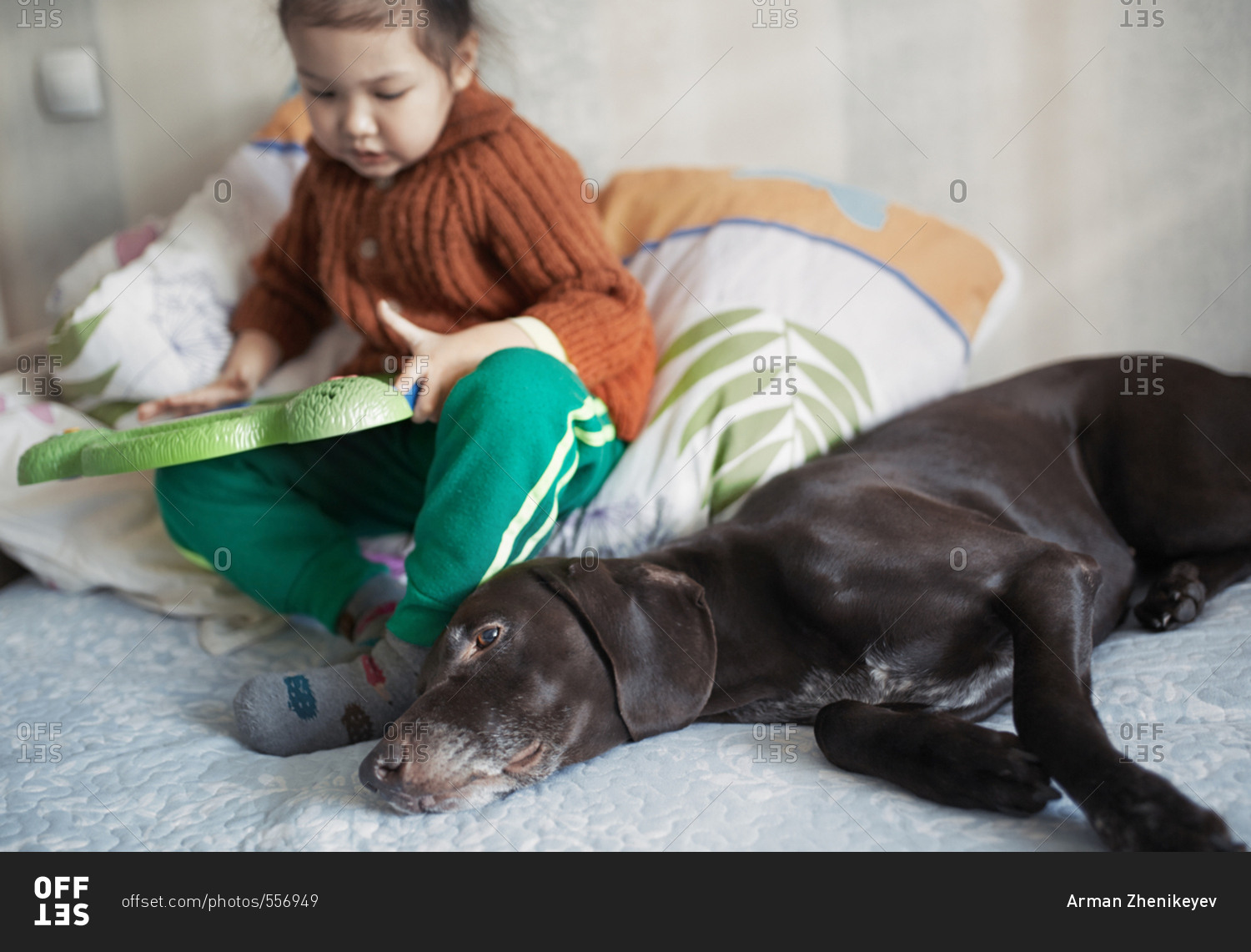 Girl playing interactive game board near to her dog
