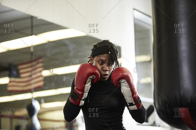 Determined female boxer practicing in health club