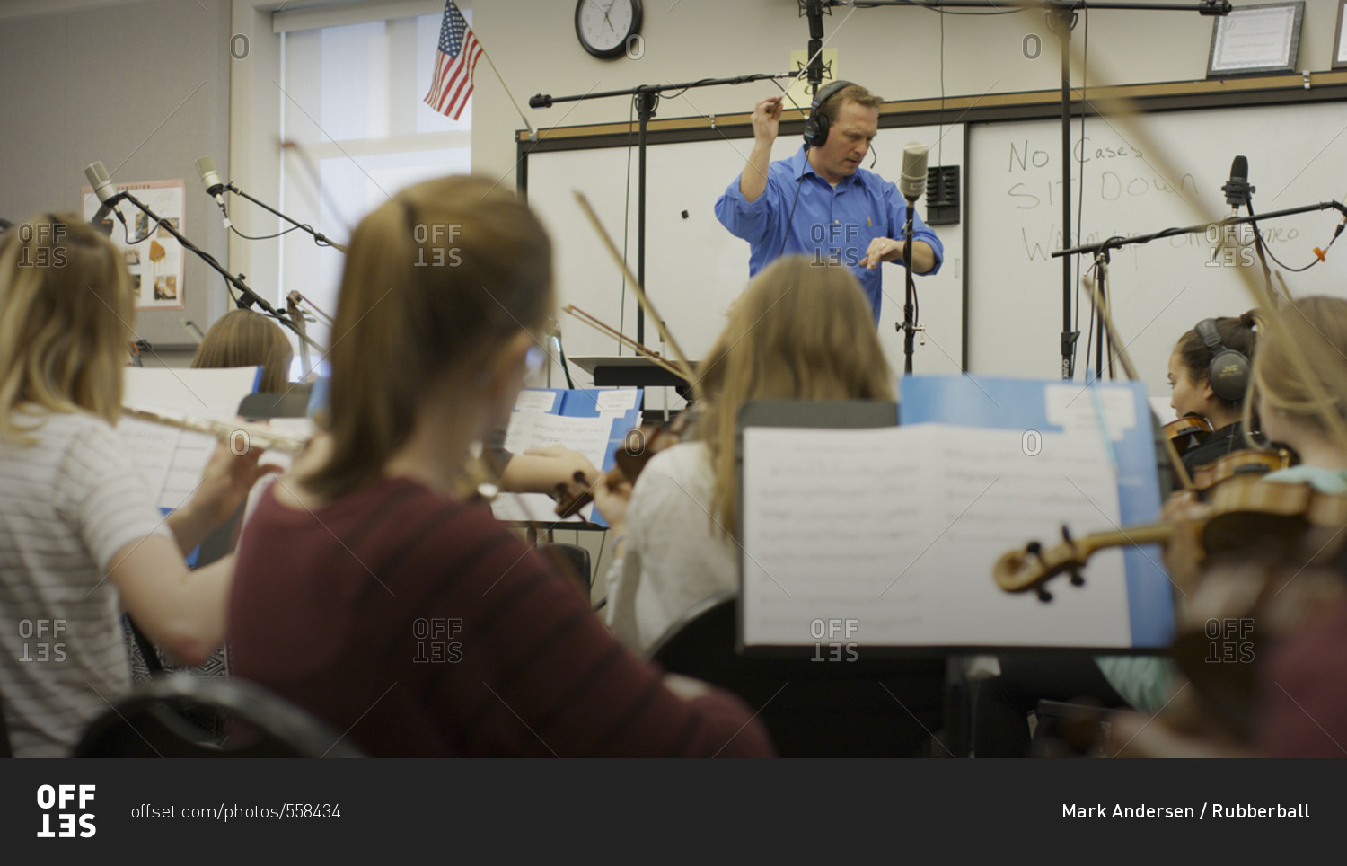 Selective focus view of teacher conducting musicians in band class