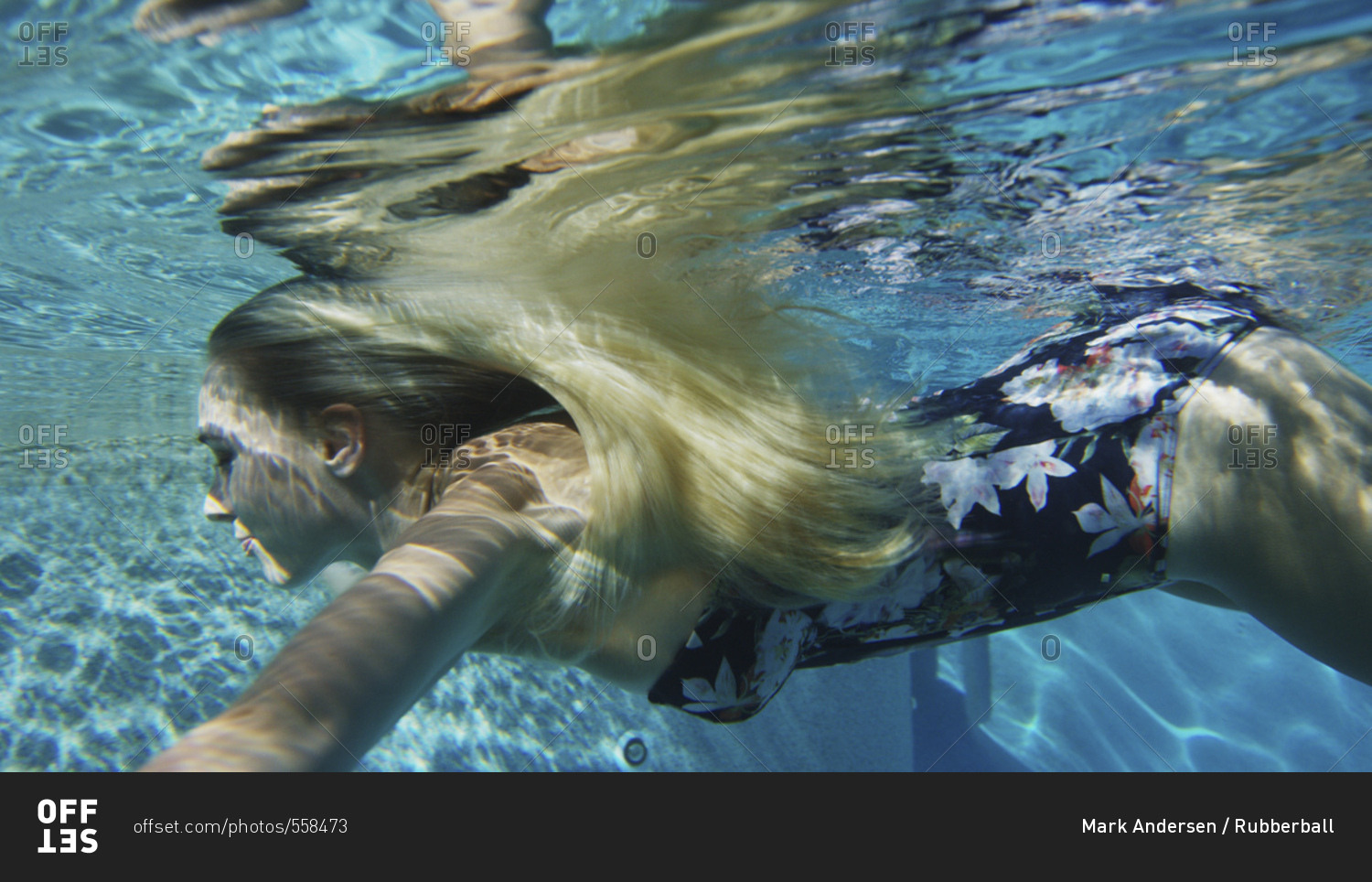 Underwater view of woman in bikini swimming in pool