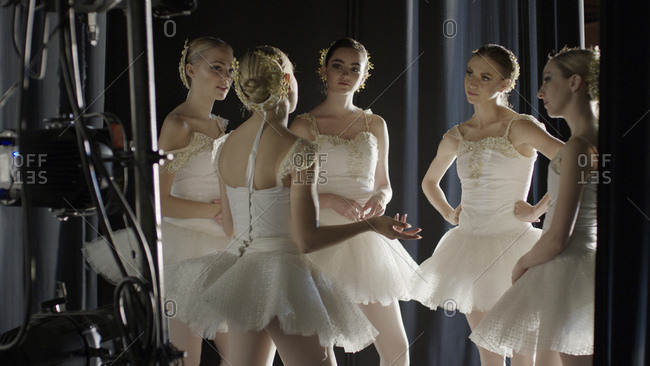 Serious ballet dancers in costume standing backstage during show