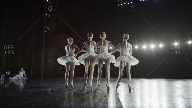 Low angle view of serious ballet dancers in costume performing onstage in show