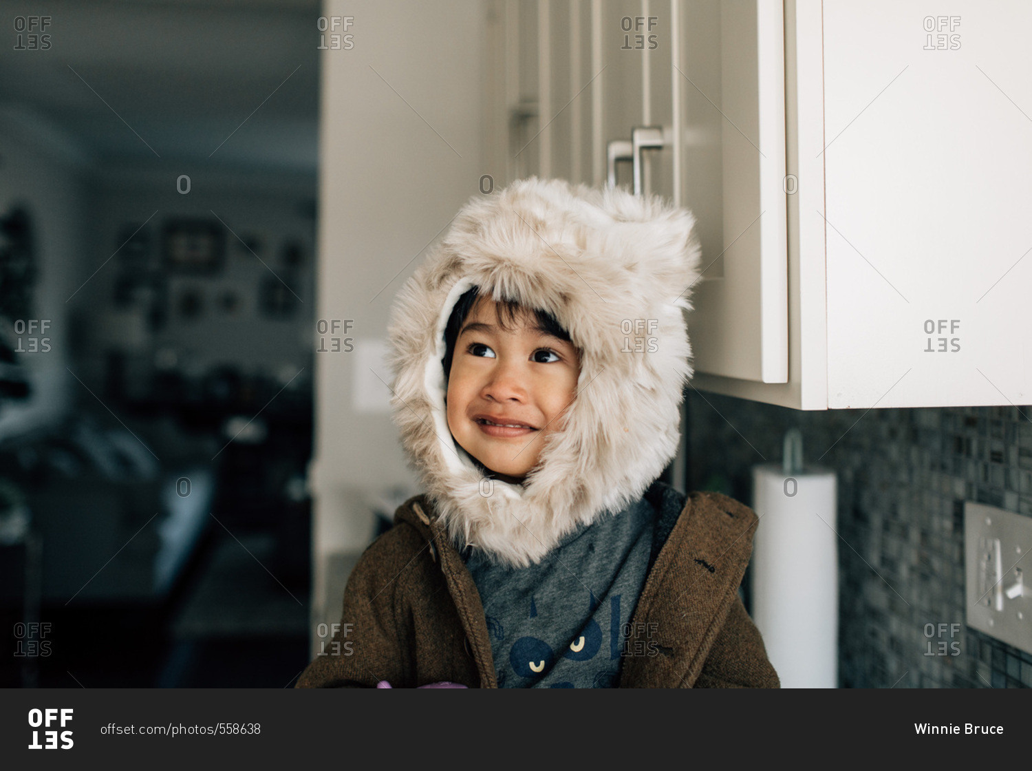 Boy in fuzzy winter hat in home