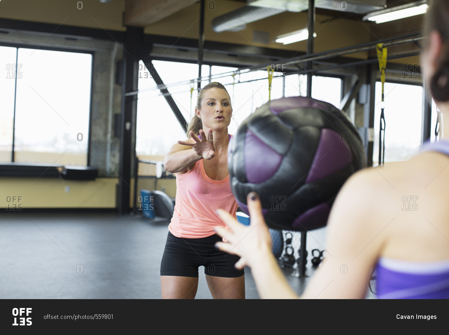 Female friends exercising with medicine ball in health club