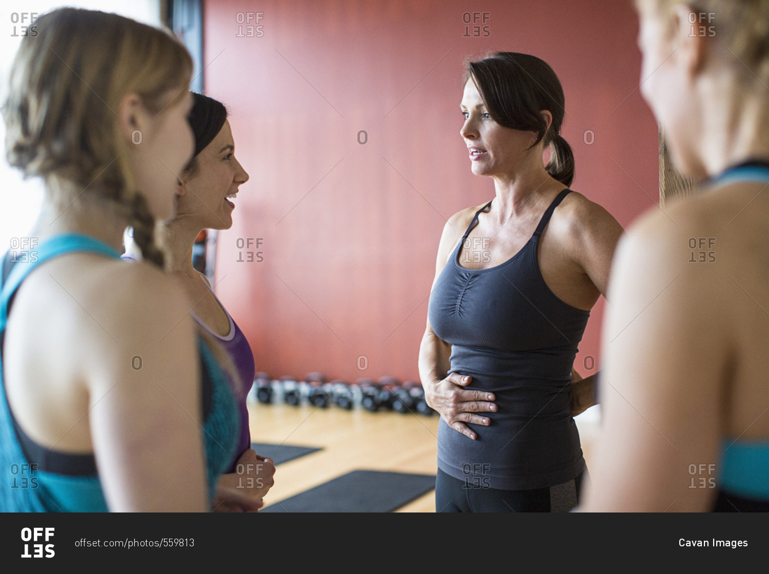 Female friends talking while standing in health club