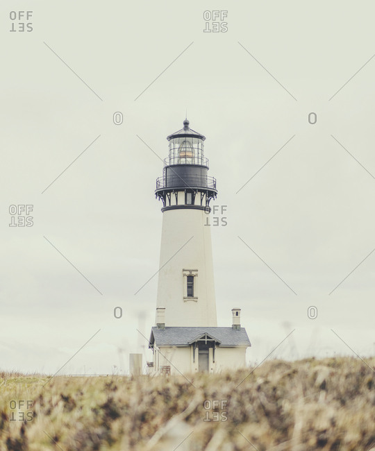 Surface level of lighthouse on field against sky