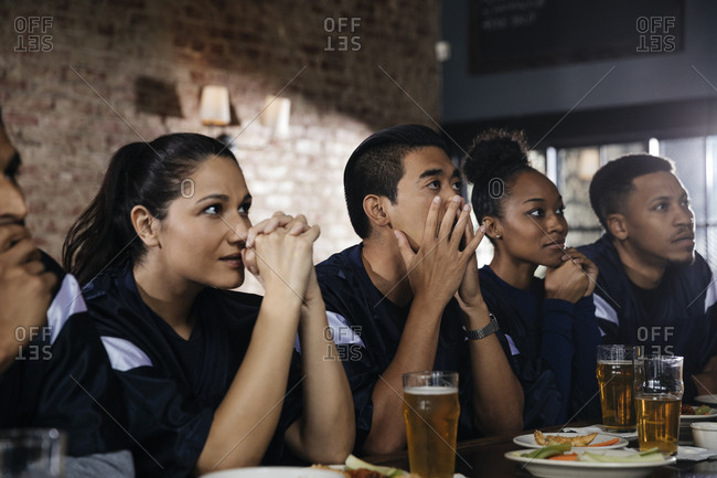 Sports fans watching TV at bar in pub