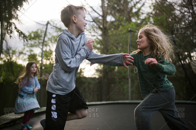 undgå Egetræ Blive opmærksom Kids wrestling around on trampoline stock photo - OFFSET