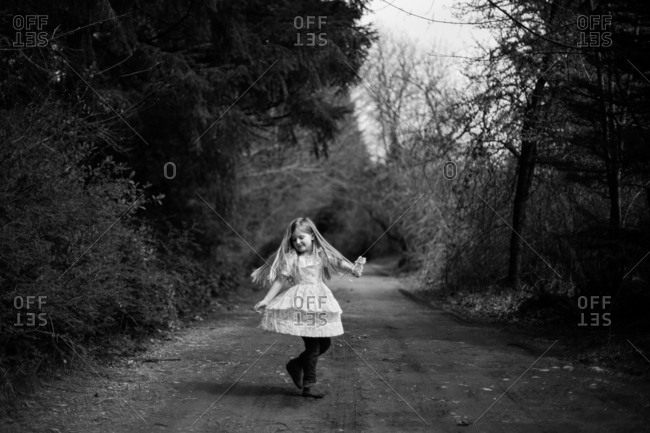 Girl spinning on rural dirt road