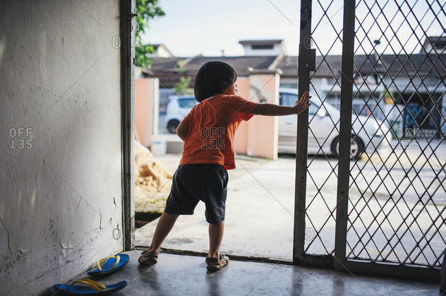 Boy in Malaysian home looking out door